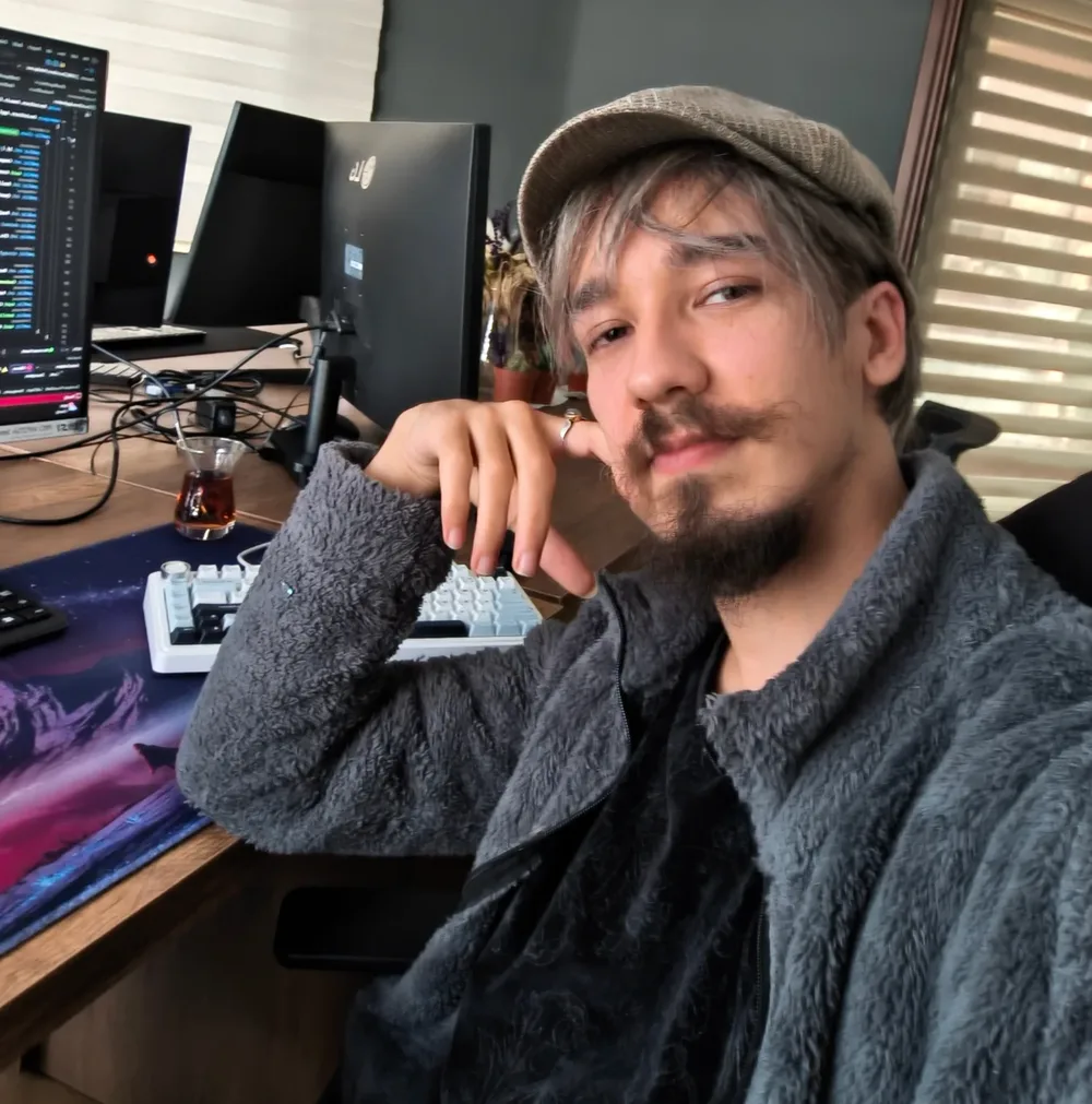 Efe sitting beside his development setup at home.