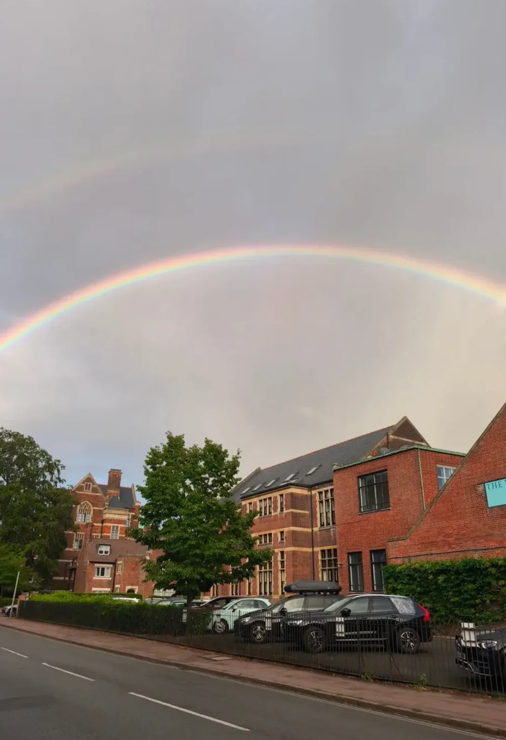 A rainbow stretching over brick buildings near The Leys.